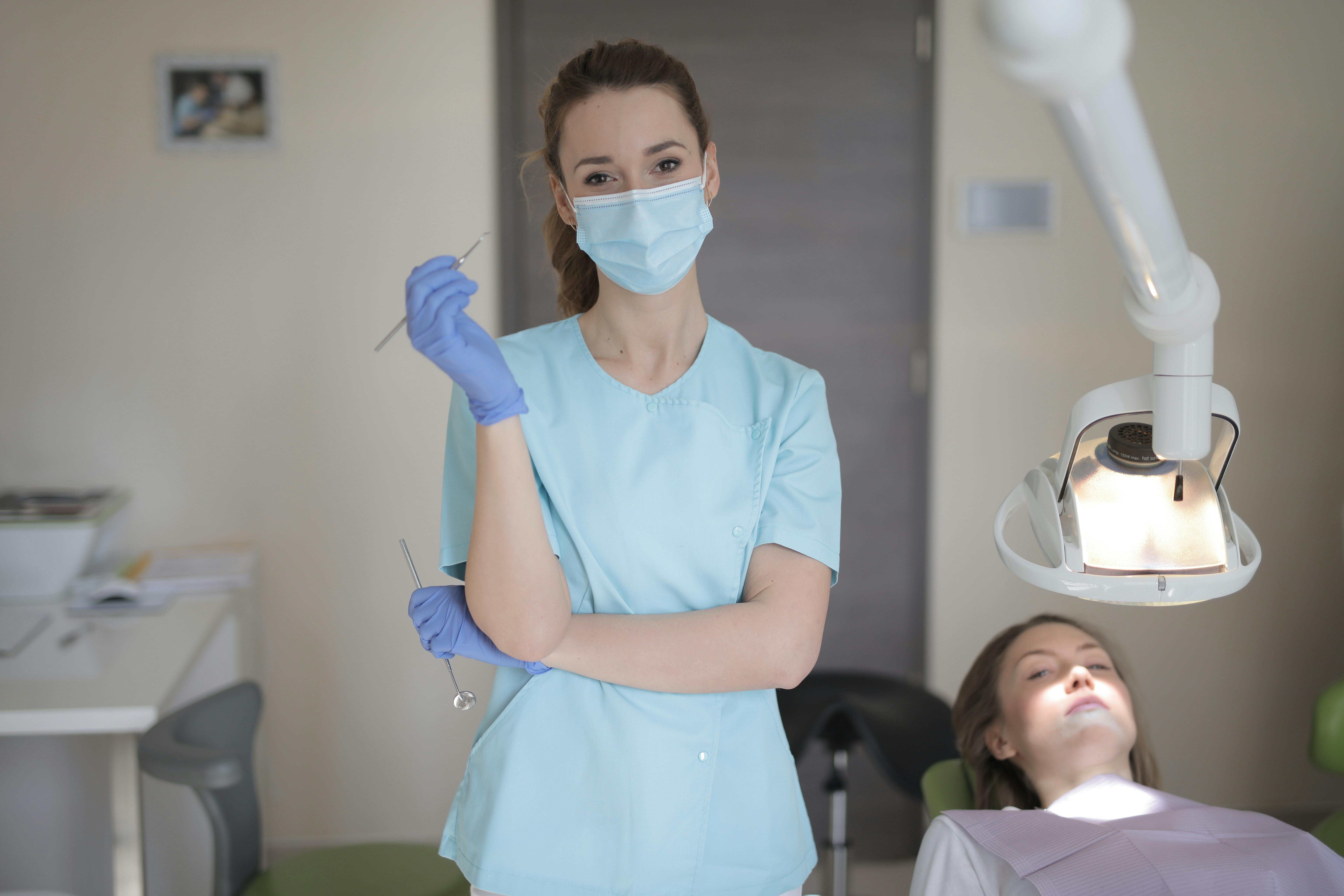 Profissional de odontologia em atendimento com iluminação clínica